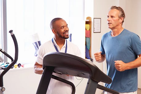 Physical Therapist with a male patient running on a treadmill as part of the lung cancer screening.